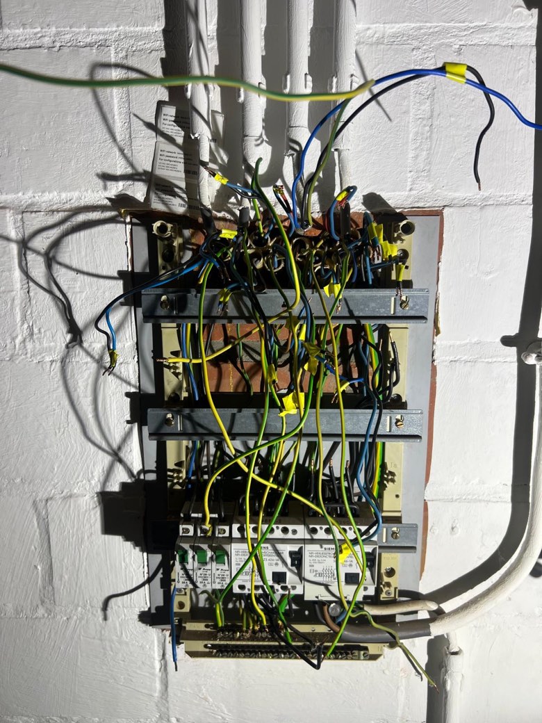 Le tableau électrique avant intervention : câbles emmêlés, connexions à nu, aucun différentiel.
